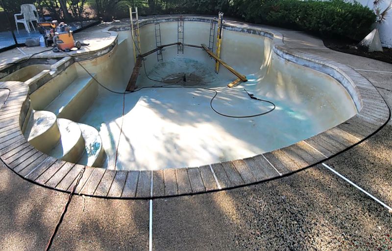 Pool deck resurfacing with polymer concrete overlay